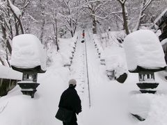 雪の石段 灯籠 赤い上着